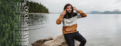 man sitting in front of a lake wearing a sustainable hoodie